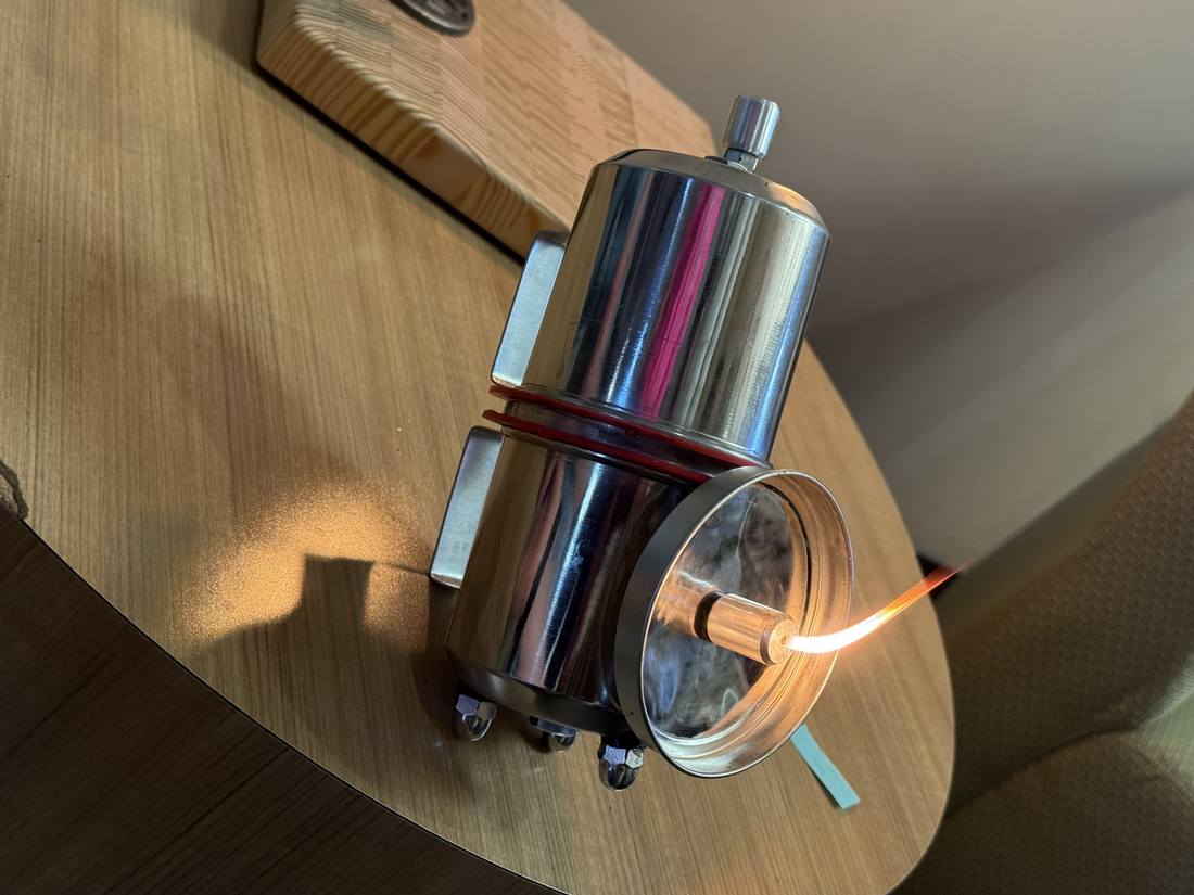 Gas lamp lit indoors showing the burner assembly