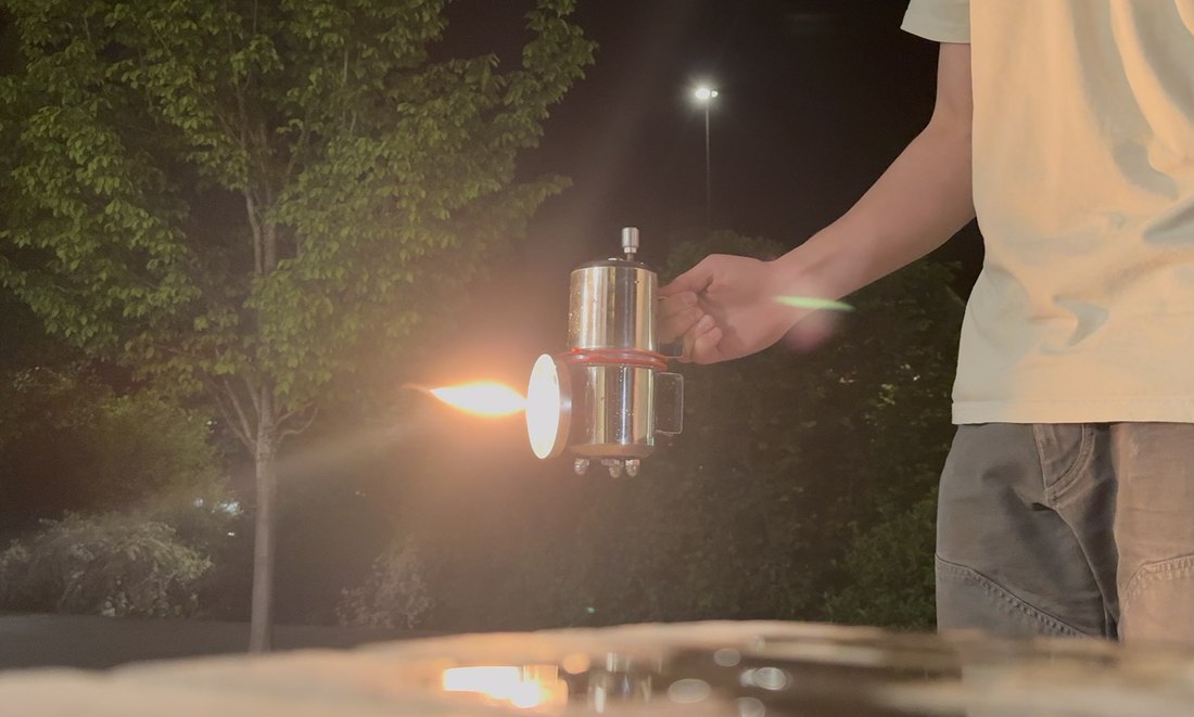 Holding the lit gas lamp outdoors at night